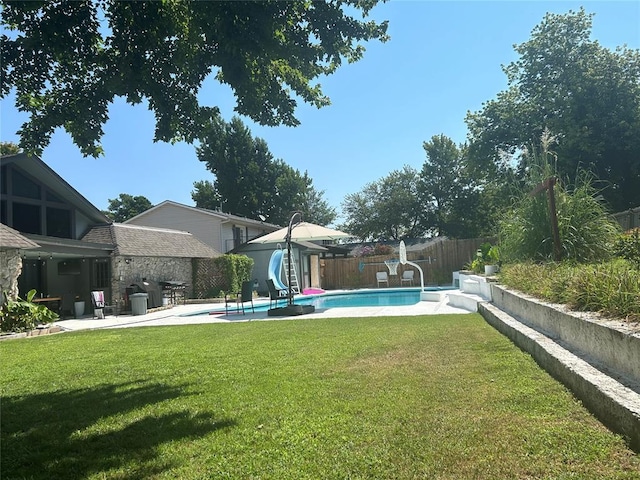 view of pool featuring a patio area, a yard, and a water slide