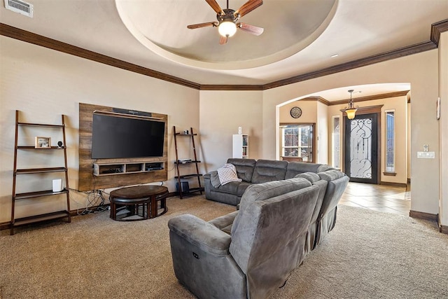 carpeted living room featuring ceiling fan, crown molding, and a tray ceiling