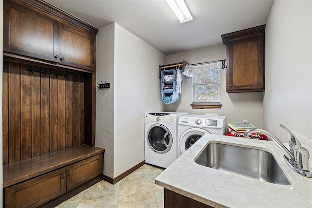 laundry room with cabinets, independent washer and dryer, and sink