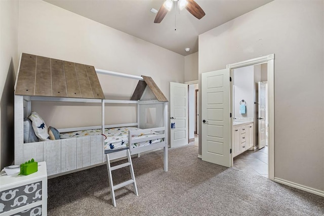 bedroom featuring light carpet, ensuite bath, ceiling fan, and lofted ceiling