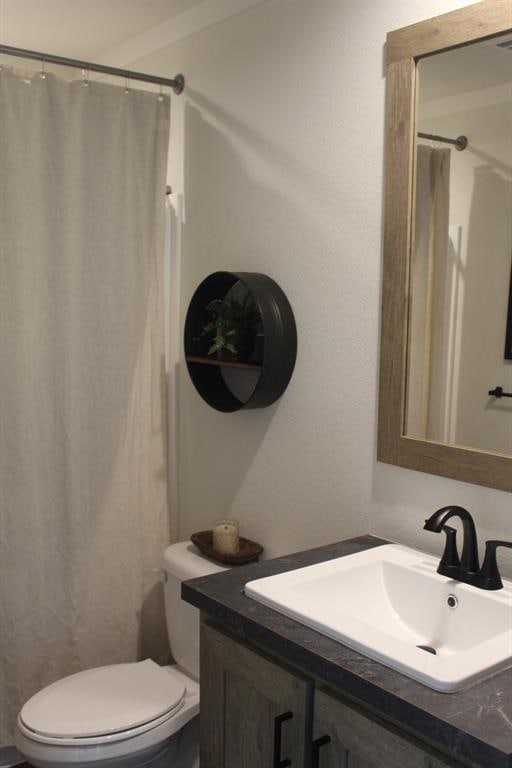 bathroom with vanity, a shower with shower curtain, and toilet