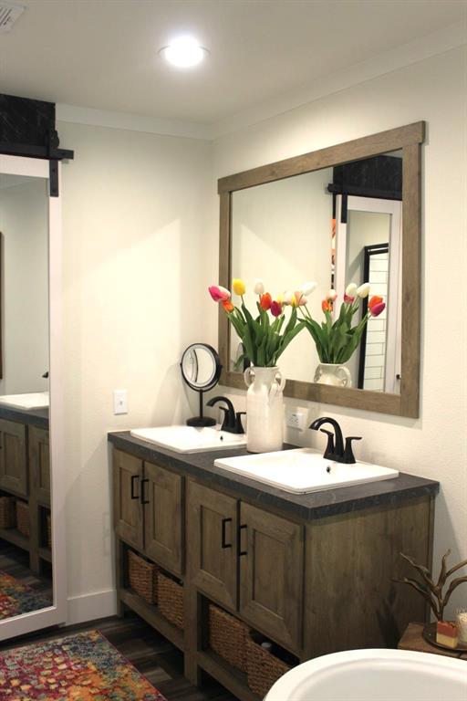 bathroom with crown molding, vanity, and hardwood / wood-style flooring