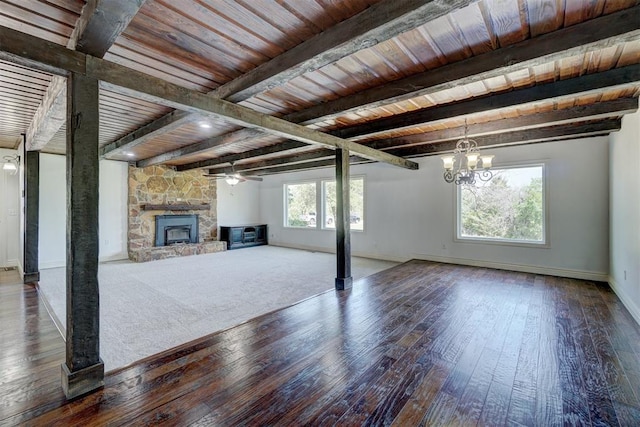 unfurnished living room with ceiling fan with notable chandelier, a stone fireplace, hardwood / wood-style flooring, beam ceiling, and wood ceiling