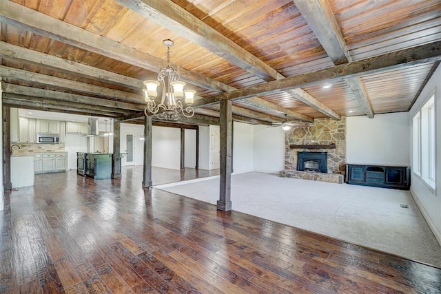 basement with hardwood / wood-style floors, wooden ceiling, ceiling fan with notable chandelier, sink, and a fireplace