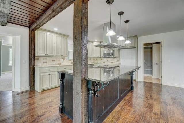 kitchen featuring backsplash, light stone countertops, hardwood / wood-style floors, and hanging light fixtures