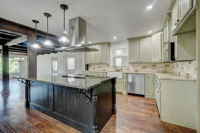 kitchen featuring appliances with stainless steel finishes, light stone counters, island range hood, wood-type flooring, and hanging light fixtures