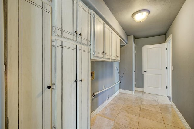 interior space with cabinets, a textured ceiling, and light tile patterned flooring