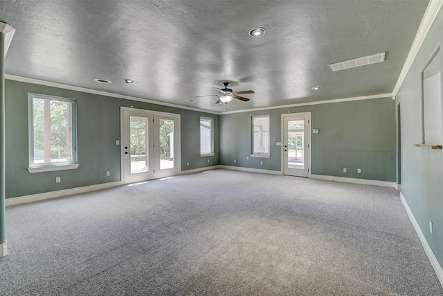 unfurnished living room featuring plenty of natural light, ornamental molding, and light carpet