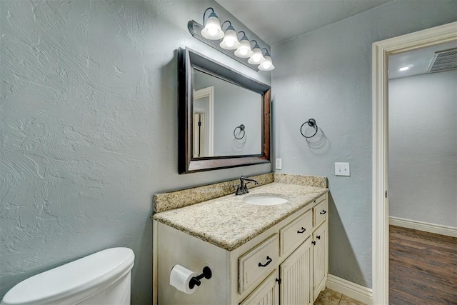 bathroom featuring vanity, wood-type flooring, and toilet