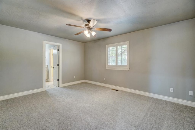 carpeted spare room with ceiling fan and a textured ceiling