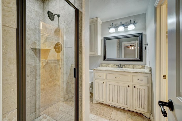 bathroom featuring toilet, vanity, tile patterned floors, and an enclosed shower