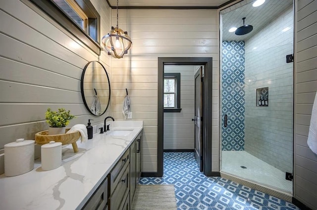 bathroom featuring vanity, an enclosed shower, and wooden walls