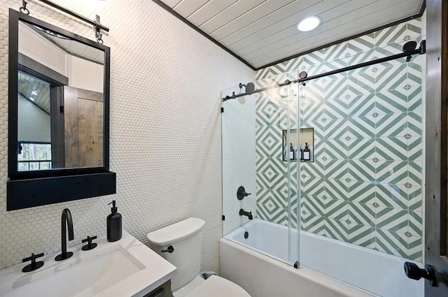 full bathroom with vanity, toilet, bath / shower combo with glass door, and tile walls