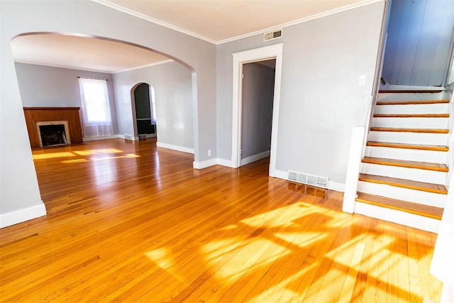 unfurnished living room featuring crown molding and hardwood / wood-style floors