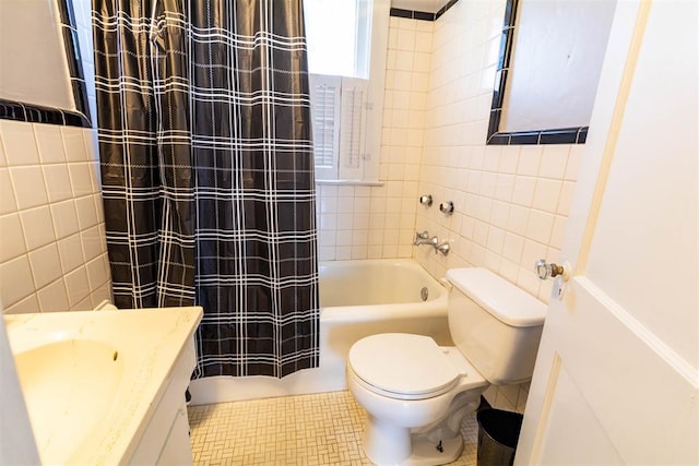 full bathroom with vanity, shower / bath combo, toilet, and tile walls