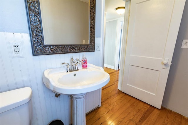 bathroom featuring toilet, wood-type flooring, and sink