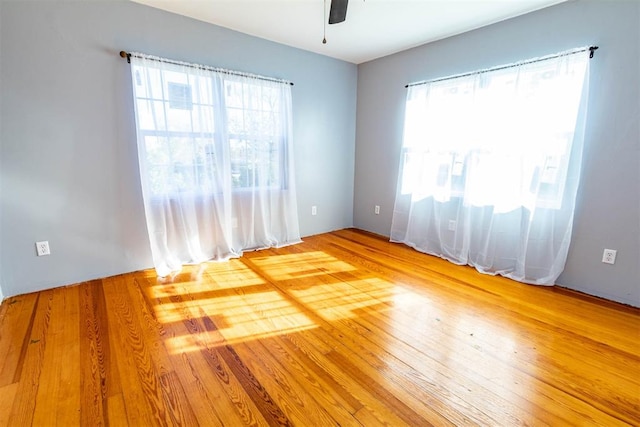 empty room featuring hardwood / wood-style flooring, plenty of natural light, and ceiling fan