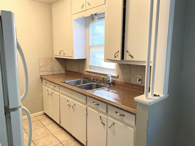 kitchen featuring tasteful backsplash, sink, white cabinets, and white refrigerator