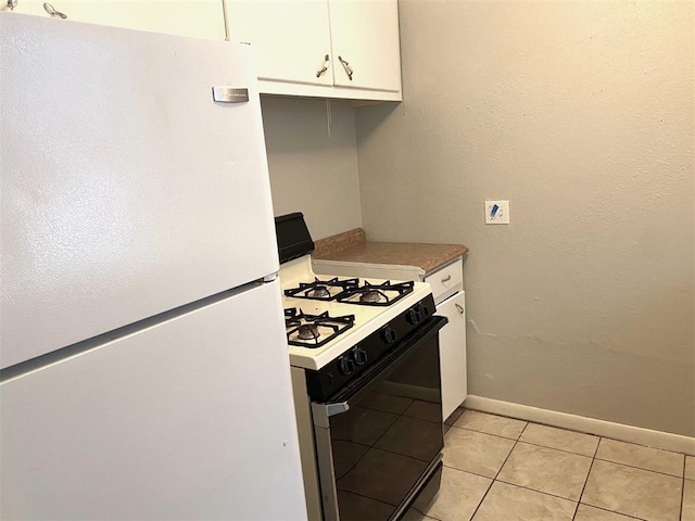 kitchen with white cabinets, white appliances, and light tile patterned floors