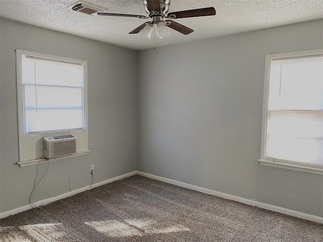 carpeted empty room with ceiling fan, cooling unit, and a textured ceiling