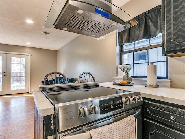 kitchen featuring stainless steel electric stove, hardwood / wood-style floors, exhaust hood, and french doors