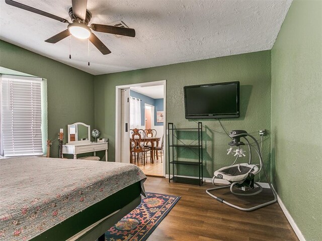 bedroom featuring a textured ceiling, dark hardwood / wood-style flooring, and ceiling fan