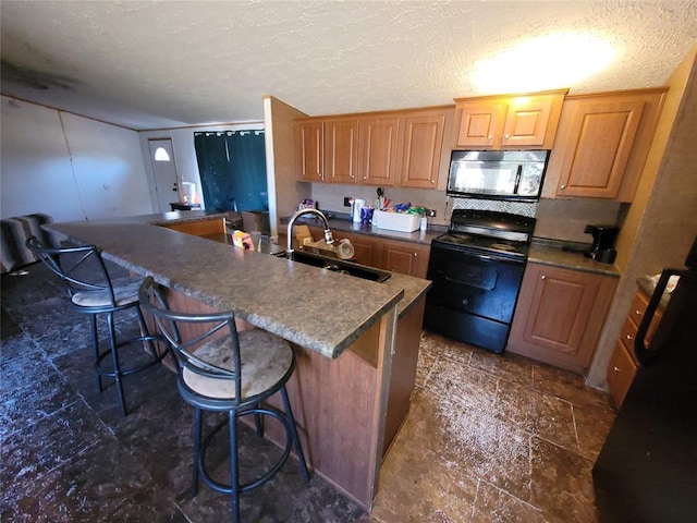 kitchen with a kitchen bar, black range with electric stovetop, sink, and a textured ceiling