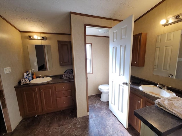 bathroom with vanity, toilet, ornamental molding, and a textured ceiling