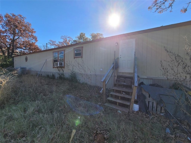 rear view of property featuring central AC unit and cooling unit