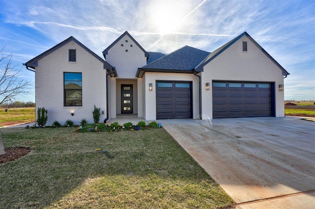 modern farmhouse featuring a garage and a front lawn