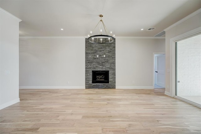 unfurnished living room with a notable chandelier, light hardwood / wood-style floors, crown molding, and a fireplace