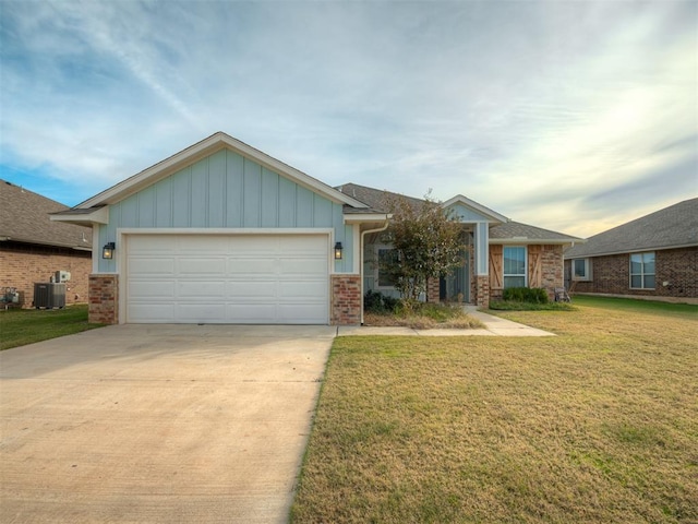 view of front of house featuring a front yard, a garage, and cooling unit