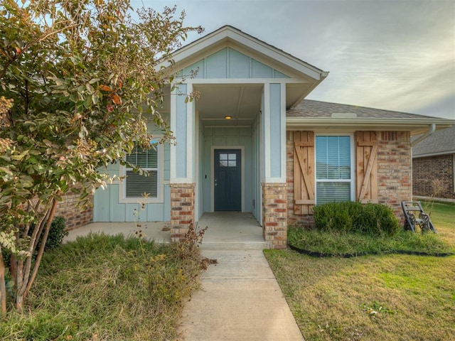 entrance to property with a lawn