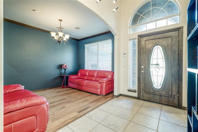 foyer featuring a notable chandelier, wood-type flooring, and crown molding