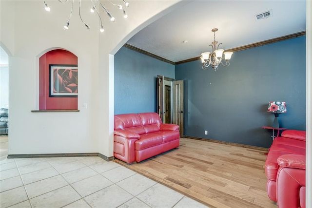 living room with hardwood / wood-style flooring, an inviting chandelier, and crown molding