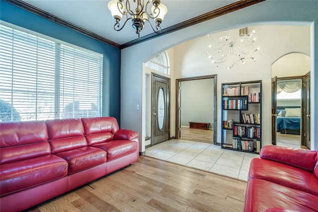 living room with a chandelier, crown molding, and light hardwood / wood-style floors