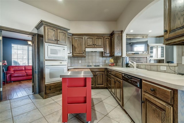 kitchen featuring sink, light tile patterned floors, stainless steel appliances, and tasteful backsplash