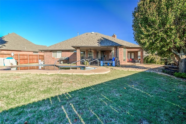 back of property with a patio area and a lawn