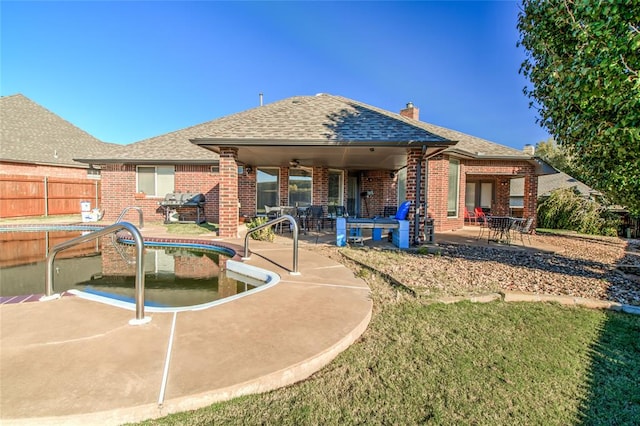 rear view of property featuring a pool, ceiling fan, and a patio area