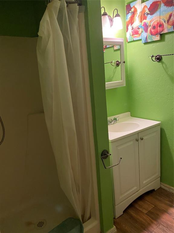 bathroom featuring hardwood / wood-style floors, vanity, and walk in shower