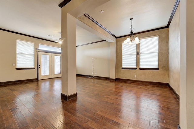 unfurnished room featuring crown molding, dark wood-type flooring, and a notable chandelier