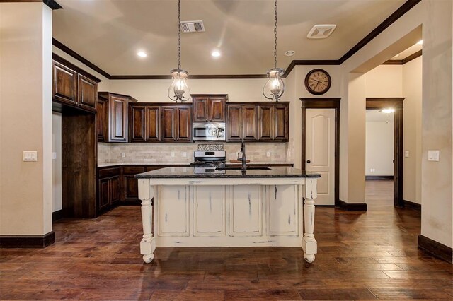 kitchen with a center island with sink, sink, stainless steel appliances, and a breakfast bar area