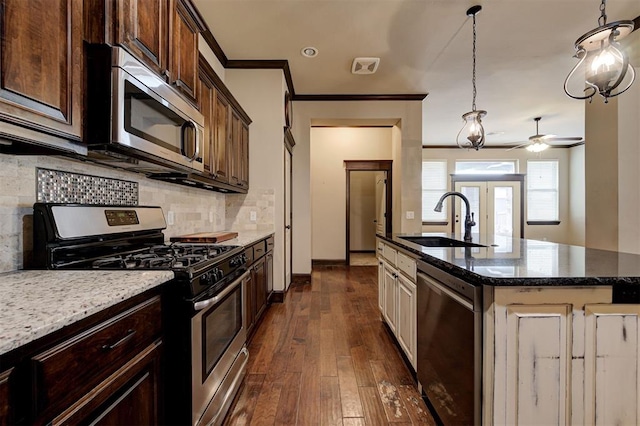 kitchen featuring appliances with stainless steel finishes, dark hardwood / wood-style flooring, a kitchen island with sink, ceiling fan, and sink