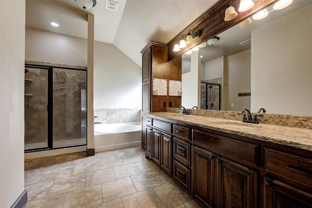 bathroom featuring tile patterned flooring, shower with separate bathtub, vanity, and vaulted ceiling