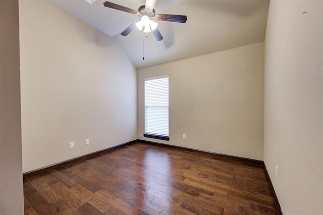 spare room featuring dark hardwood / wood-style floors, vaulted ceiling, and ceiling fan