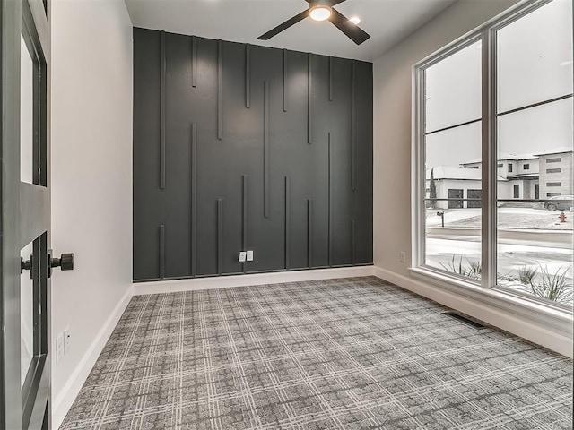 empty room featuring ceiling fan and plenty of natural light