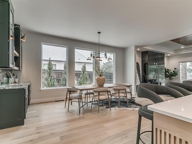 dining room featuring light hardwood / wood-style floors, an inviting chandelier, and sink