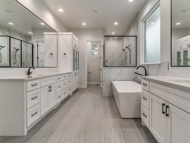 bathroom featuring vanity, independent shower and bath, and tile walls