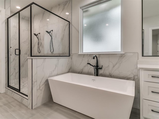 bathroom featuring tile patterned flooring, vanity, and shower with separate bathtub