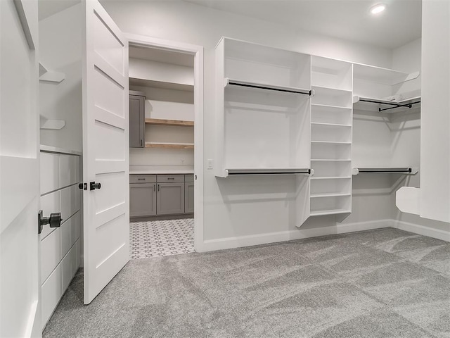 walk in closet featuring light carpet